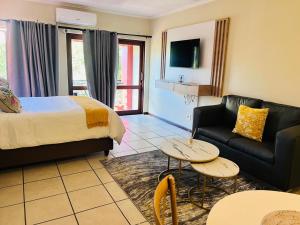 een hotelkamer met een bed en een bank bij Rockmel Apartment in Sandton