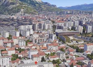 eine Luftansicht auf eine Stadt mit Gebäuden und Bergen in der Unterkunft L'aube Climatisation Parking 2 chambres in Grenoble