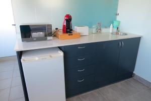 - une cuisine avec un comptoir, un four micro-ondes et un évier dans l'établissement The Sundowner Room, à Langebaan 1 autre photo