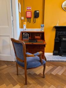 a chair in front of a desk with a phone at The Sardinian Guesthouse (6 Bedrooms) in Cobh
