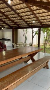 ein großer Holztisch unter einem Holzdach in der Unterkunft Rancho paraíso - Refúgio tranquilo, vista incrível in Lajeado