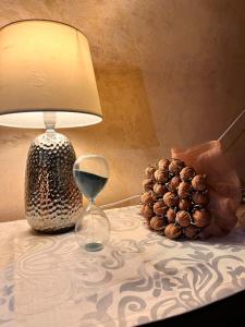 een tafel met een lamp, een wijnglas en een ananas bij Cip-Apartament24 in Iaşi