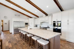 a kitchen with white cabinets and a large island with bar stools at Calaboose Retreat in Campton