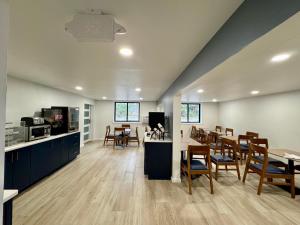 a dining room and kitchen with tables and chairs at Super 8 by Wyndham Mankato in Mankato