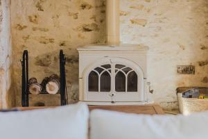a room with a white stove in a room at Le Logis de Saint-Chamassy in Saint-Chamassy