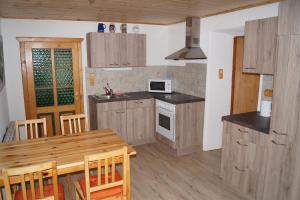 a kitchen with a wooden table and a dining room at FW Langanger in Fischerndorf
