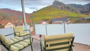 a balcony with chairs and a view of a mountain at Black Forest -5- I Design-Apartment I 2 Etagen I Terrasse & Balkon mit Ausblick I Boxspring I Nespresso in Oberharmersbach