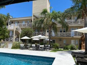 a hotel with a swimming pool in front of a building at Posada Atama in Gualeguaychú