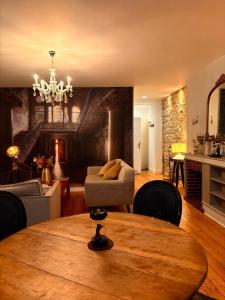 a living room with a table and a chandelier at L'Idéal - charme de l'ancien et modernité - Hyper Centre in Vannes