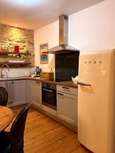 a kitchen with a refrigerator and a table at L'Idéal - charme de l'ancien et modernité - Hyper Centre in Vannes
