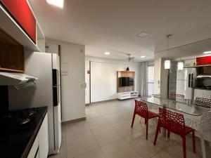 a kitchen with a table and chairs and a refrigerator at Apartamento 2 quartos Meireles a uma quadra da Beira-mar - My Way in Fortaleza