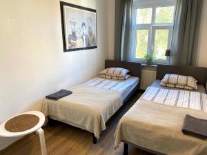 a room with two beds and a window at Lemuria Hostel Szkolna centrum in Legnica