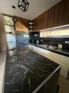eine Küche mit einer Arbeitsplatte aus schwarzem Marmor in der Unterkunft El descanso in Villa del Dique + 12 Fotos