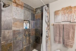 ein Bad mit einer Dusche und einer Steinmauer in der Unterkunft Amazing Views Central AC 5 ac of Privacy Lawn Games and HOT TUB in Elden Pueblo + 45 Fotos