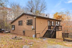 a small house with a staircase in a yard at River Access Cabin with Hot Tub, Fire Pit, & WiFi! in Morton Grove