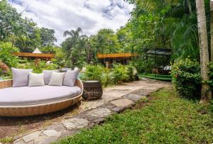 Un jardín con un sofá en el césped. en Ocho Artisan Bungalows, en Tamarindo