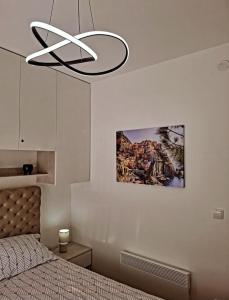 a bedroom with a bed and a chandelier at La Casa in Vrnjačka Banja