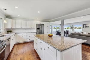 a kitchen with white cabinets and a large counter top at Month to Month and Seasonal Luxury Lakefront 5 bed 5 5 bath Estate Home in Ingleside +16 photos