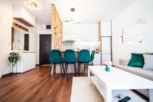 a living room with a couch and green chairs at La Casa in Vrnjačka Banja