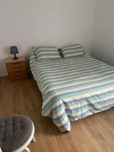 a bed with a blanket on it in a bedroom at Maison Le 108 in Lamballe Armor