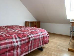 a bedroom with a bed and a wooden floor at Maison Le 108 in Lamballe Armor