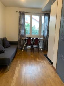 a living room with a couch and chairs and a table at Studio Spacieux au Grand Paris in Chennevières-sur-Marne