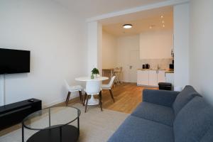 un salon avec un canapé bleu et une table dans l'établissement Appartment Astrid 4, à Bruxelles
