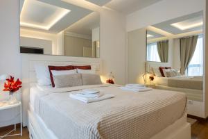 Un dormitorio blanco con una cama grande con toallas. en Bw Zuma Apartments, en Belgrado
