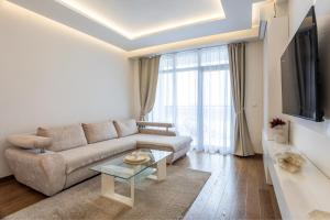 Una sala de estar con un sofá y un televisor en Bw Zuma Apartments, en Belgrado