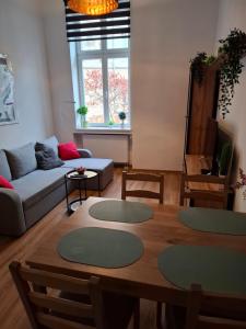 a living room with a table and a couch at Apartament Love on 5 - Miłość na 5 in Legnica +18 photos