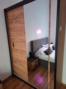 einen Spiegel vor einem Schlafzimmer mit einem Bett in der Unterkunft Apartament Love on 5 - Miłość na 5 in Legnica