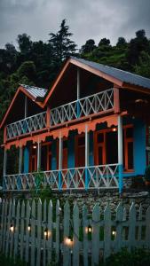 a house with a fence in front of it at Selah by soho house in Jibhi