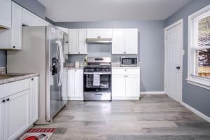 a kitchen with white cabinets and stainless steel appliances at The Main Stay - Mineola Bay Lakeview and Access - Fully Furnished Monthly & Seasonal Rental in Fox Lake in Fox Lake +34 photos