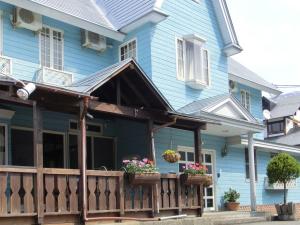 a blue house with a porch with flowers on it at Minamiuonuma - Hotel - Vacation STAY 23091v in Myōgasawa +14 photos