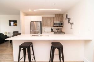 een keuken met een groot wit aanrecht met twee krukken bij Corporate Stays Junction 1 Bedroom in Halifax