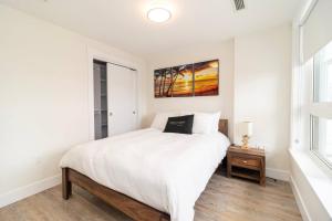 een witte slaapkamer met een bed en een raam bij Corporate Stays Junction 1 Bedroom in Halifax +5 foto's