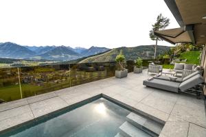a patio with a swimming pool with a view of mountains at Alpin Chalet Dachsteinhaus in Ramsau am Dachstein