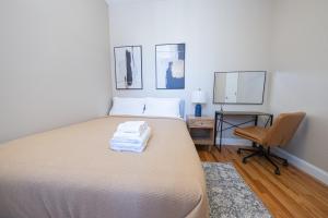 a bedroom with a bed and a desk and a chair at Sunlit 2BR Central Park North elevator & laundry in New York