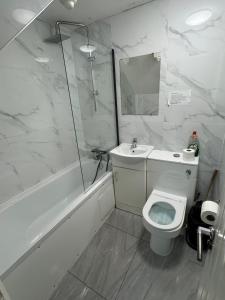 a bathroom with a toilet and a shower and a sink at Family room in Zone 2 in London