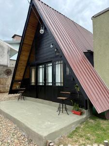 a black house with a red metal roof at Cantinho do Vale# in Pomerode +18 photos