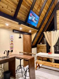a kitchen with a table and a tv on the ceiling at Cantinho do Vale# in Pomerode