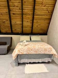 a bedroom with a bed with a wooden ceiling at Cantinho do Vale# in Pomerode