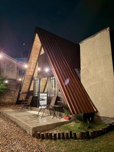 a house with a red roof with chairs outside at night at Cantinho do Vale# in Pomerode