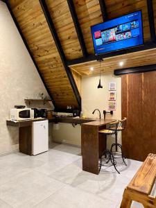 a kitchen with a table and a tv on the ceiling at Cantinho do Vale# in Pomerode