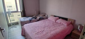 a bedroom with a bed with pink sheets and a window at Chambre privée dans grand et superbe appartement proche paris in Creil