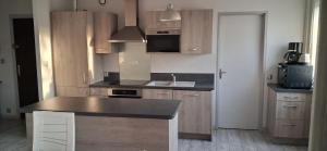 a kitchen with wooden cabinets and a counter top at Chambre privée dans grand et superbe appartement proche paris in Creil +6 photos