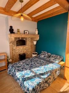 a bedroom with a bed and a stone fireplace at Maisonnette au cœur des vignes in Fixin
