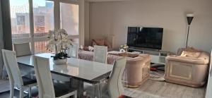 a living room with a dining table and a television at Chambre privée dans grand et superbe appartement proche paris in Creil