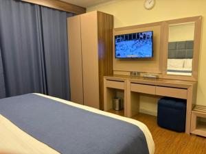 a hotel room with a bed and a desk with a tv at Swiss Blue serviced Apartments- Al Zahra in Jeddah