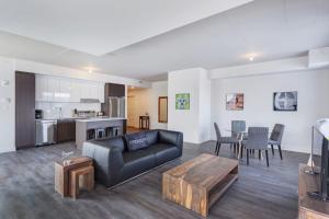 ein Wohnzimmer mit einer schwarzen Couch und einem Tisch in der Unterkunft Corporate Stays Equinoxe 2 Bedroom in Chomedey